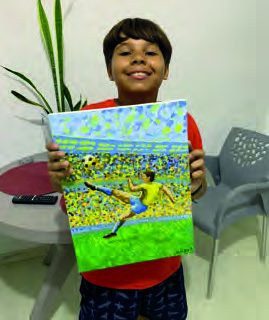 Aluno do curso infantil mostra pintura de jogador de futebol